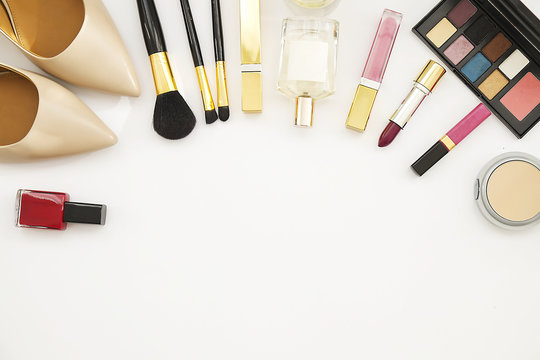 Women's Cosmetics And Accessories. Nail Polish, Eye Shadow, Brush, Perfume, Red Cosmetic Bag And Nude Shoes. Top View Text Space