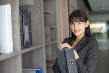 Asian woman holding document at working place, woman working concept.