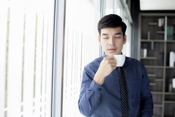 Fototapeta na wymiar Asian Businessman drinking coffee at the morning.