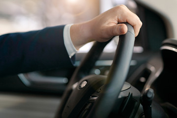 Male hand on a steering wheel