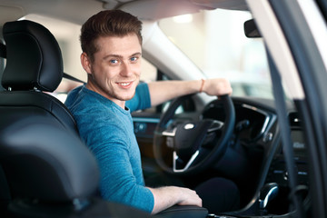 Happy young male driver behind the wheel