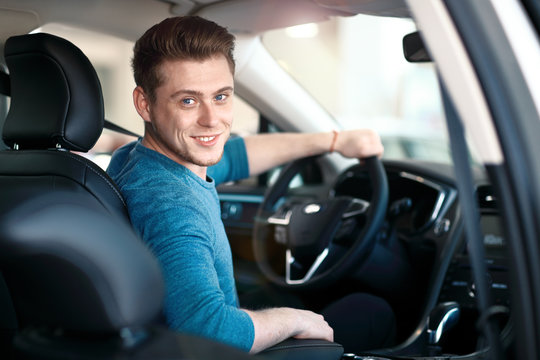 Happy young male driver behind the wheel