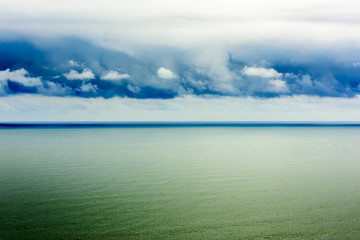 Fototapeta premium Stylized abstract landscape seascape sunset long exposure with clouds under different shades of blue, orange, yellow and red.