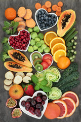 Super food for a high fibre diet with fresh fruit and vegetables, concept of foods high in smart carbohydrates, antioxidants and vitamins, on marble background, top view.