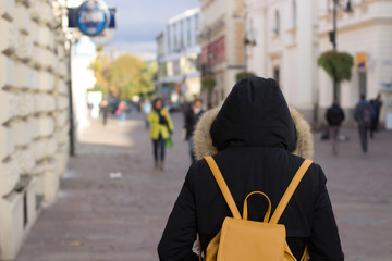 girl with backpack walking at city center