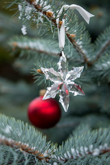 Snowy Christmas tree, decorated with red globe and crystal flake