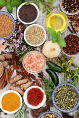 Fresh and dried herbs and spices in bowls and loose forming a colourful abstract background. Top view.