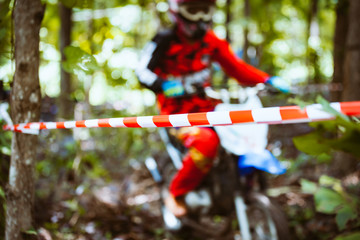Close-up of barricade plastic rope with mountain bikes racing in jungle in blur background. Concept of focus during an accelerate in action sport