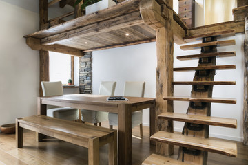 wooden table in dining room under mezzanine