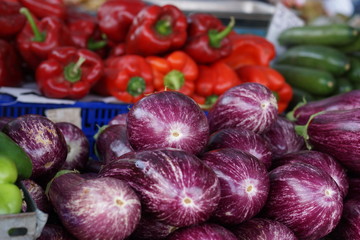 Eggplants and peppers on the vegetable counter on the market
