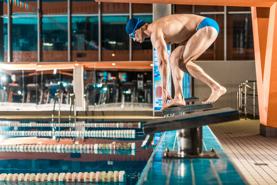 swimmer standing on diving board