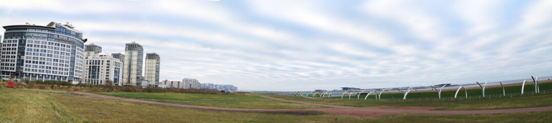panorama of the city quarter on the coast, green grass, space, morning sky