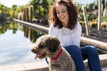 beautiful young woman having fun with her cute brown dog. Love for animals concept. Outdoors