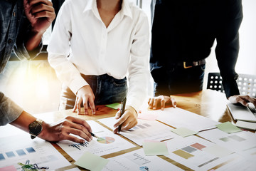 Businessman holding pens and holding graph paper are meeting to plan sales to meet targets set in...