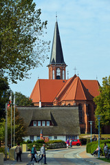Fototapeta na wymiar Kirche von Wustrow und Reetdachhaus
