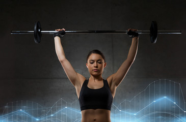 Naklejka premium young woman flexing muscles with barbell in gym