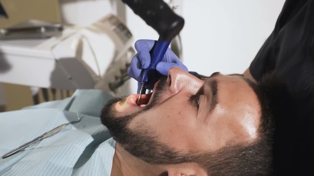 The dentist treats the patient's teeth. Medical stomatological instruments in the hands of a dentist