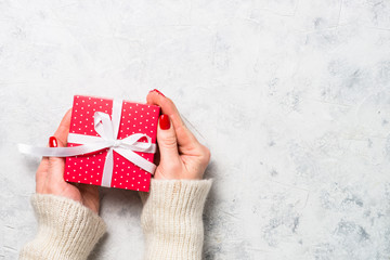 Woman packing red christmas present box.