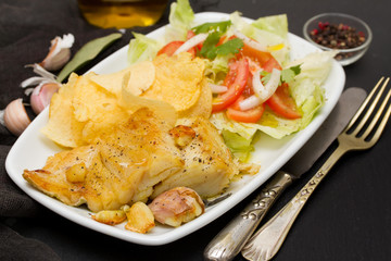 fried codfish with potato and salad on dish