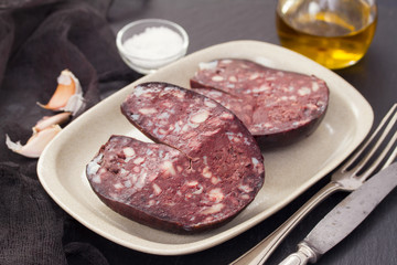 smoked sausage morsela on white dish on wooden background