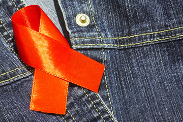 World AIDS Day. Symbol red ribbon on a blue denim shirt.