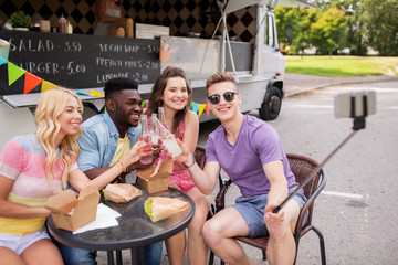happy young friends taking selfie at food truck