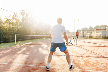 Obraz premium Man playing tennis in the morning in sunlight