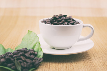 Coffee cup with coffee beans and coffee leaves