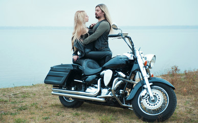 Fototapeta na wymiar Couple on a bike in a leather jackets 