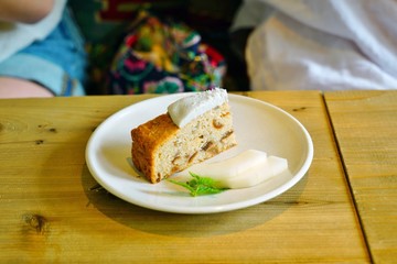 Slice of vegan apple cake with coconut whipped cream 