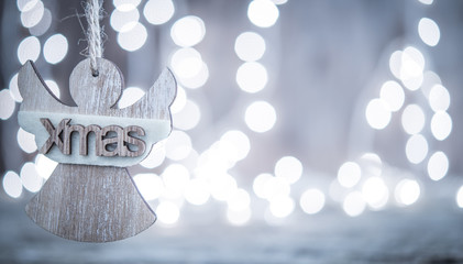 Christmas card with wooden angel and bokeh lihgts background