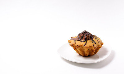 Fresh and flavored cupcake on a white plate on a white background