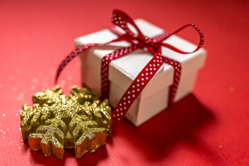 White gift box with red ribbon isolated on red color background. Merry Christmas and Happy Holidays concept.