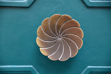 Poignée laiton en forme de rosace sur bois bleu