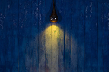 Licht eines Scheinwerfers auf einer blauen Holzwand