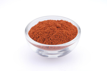 Ground paprika in glass bowl isolated on white background