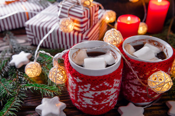 Hot chocolate with marshmallows and biscuits on Christmas decorations background.