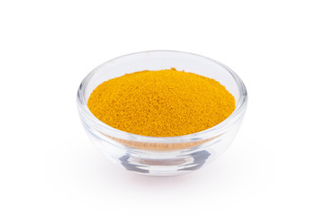 Ground turmeric in glass bowl isolated on white background