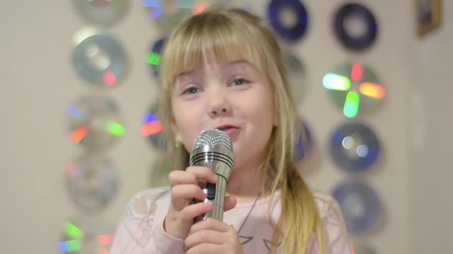 Little girl with microphone sings songs