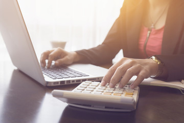 Hand woman doing finances and calculate on desk about cost at home office.businesswoman work with generic design notebook laptop for a business plan analysis. Online payments, banking,hands keyboard