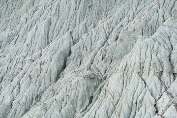Fototapeta premium The slope of the mountain with traces of water flow in Republic of Crimea background texture in grey gamma