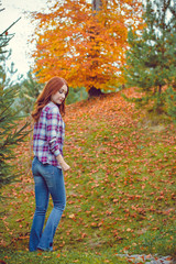 Beautiful hipster traveler with around autumn trees in woods. Stylish woman hiking. adventure and travel concept or rest at weekend on a nature, atmospheric moment