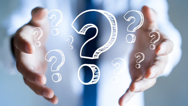 Businessman with question marks in his hand.