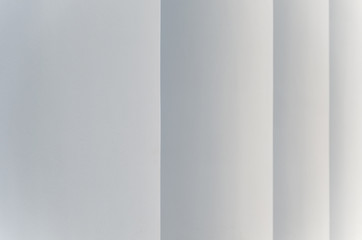 Light gray abstract background with vertical stripes that taper in the perspective as steps.