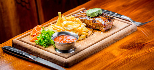 Beef steak with pepper sauce and Grilled vegetables on cutting board  dark wooden background