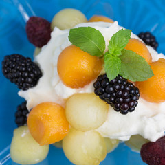 piel de sapo melon and cantaloupe on whipped cream with raspberries and blackberries