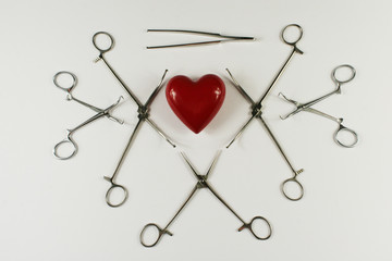 Medical surgical Instruments and heart on white background.