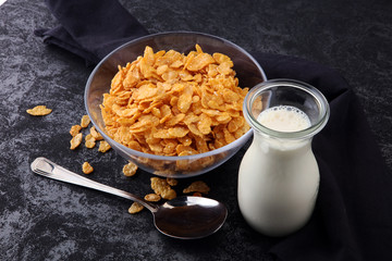 Cornflakes cereal and milk in a glass bowl. Morning breakfast concept