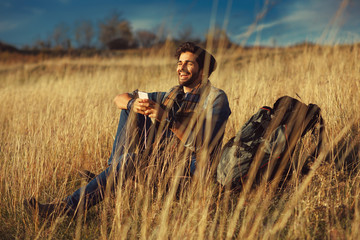 Young happy man using a smartphone in nature
