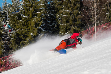 Freerider snowboarder skiing the slope at winter resort in the mountains. Forest on the background....